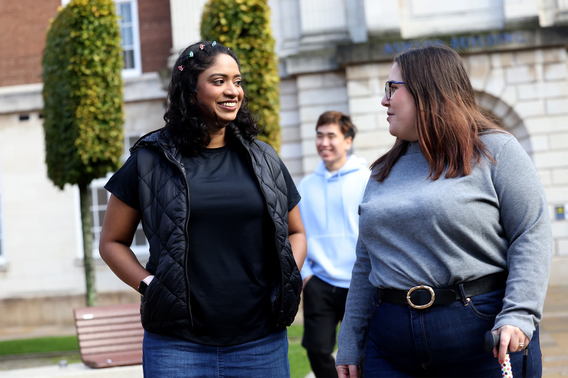 Two students walk together through campus.