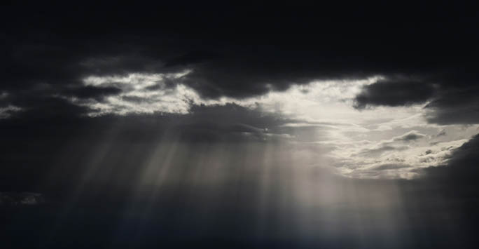 Sun shining through a cluster of dark clouds.