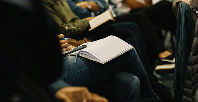 Writing notes at event.