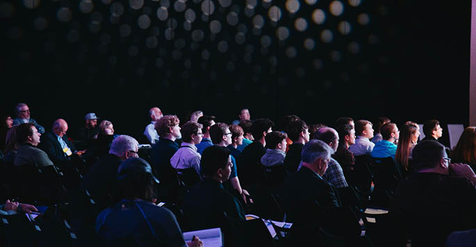 An auditorium of people attending a lecture.