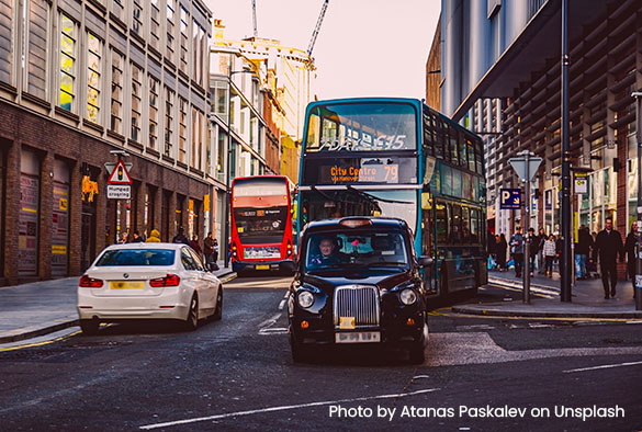 Traffic on Liverpool\'s Hanover street: a white mercedes, a black taxi cab and two double decker buses