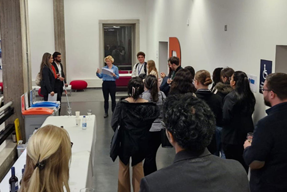 A large group of people stand together in a room.