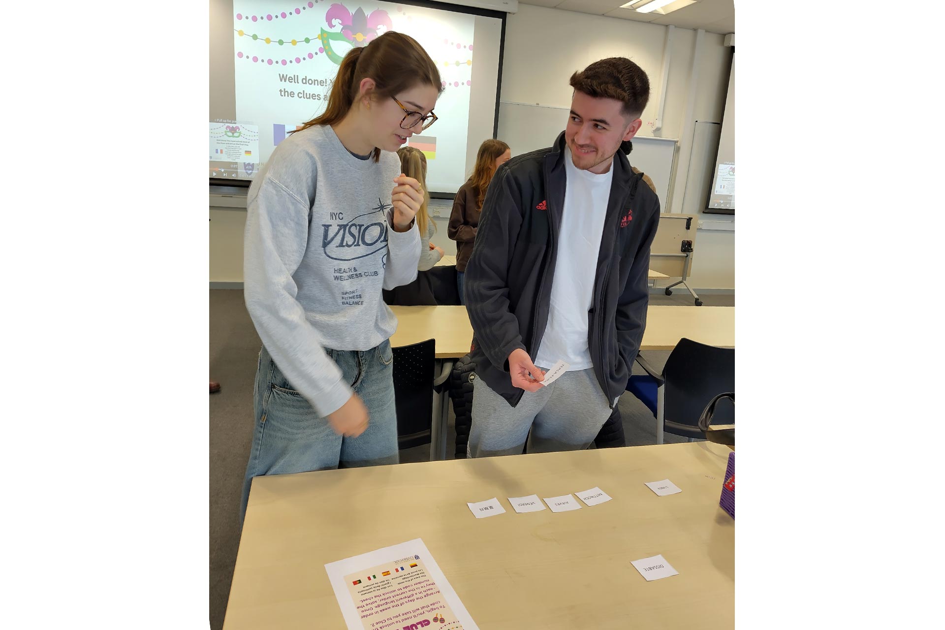 Two students talking and discussing cards laid out on the table in front of them