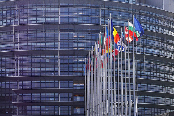 Flags in front of a modern building.
