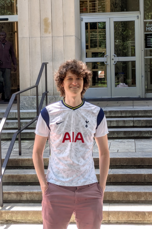 Student standing facing the camera with crossed hands