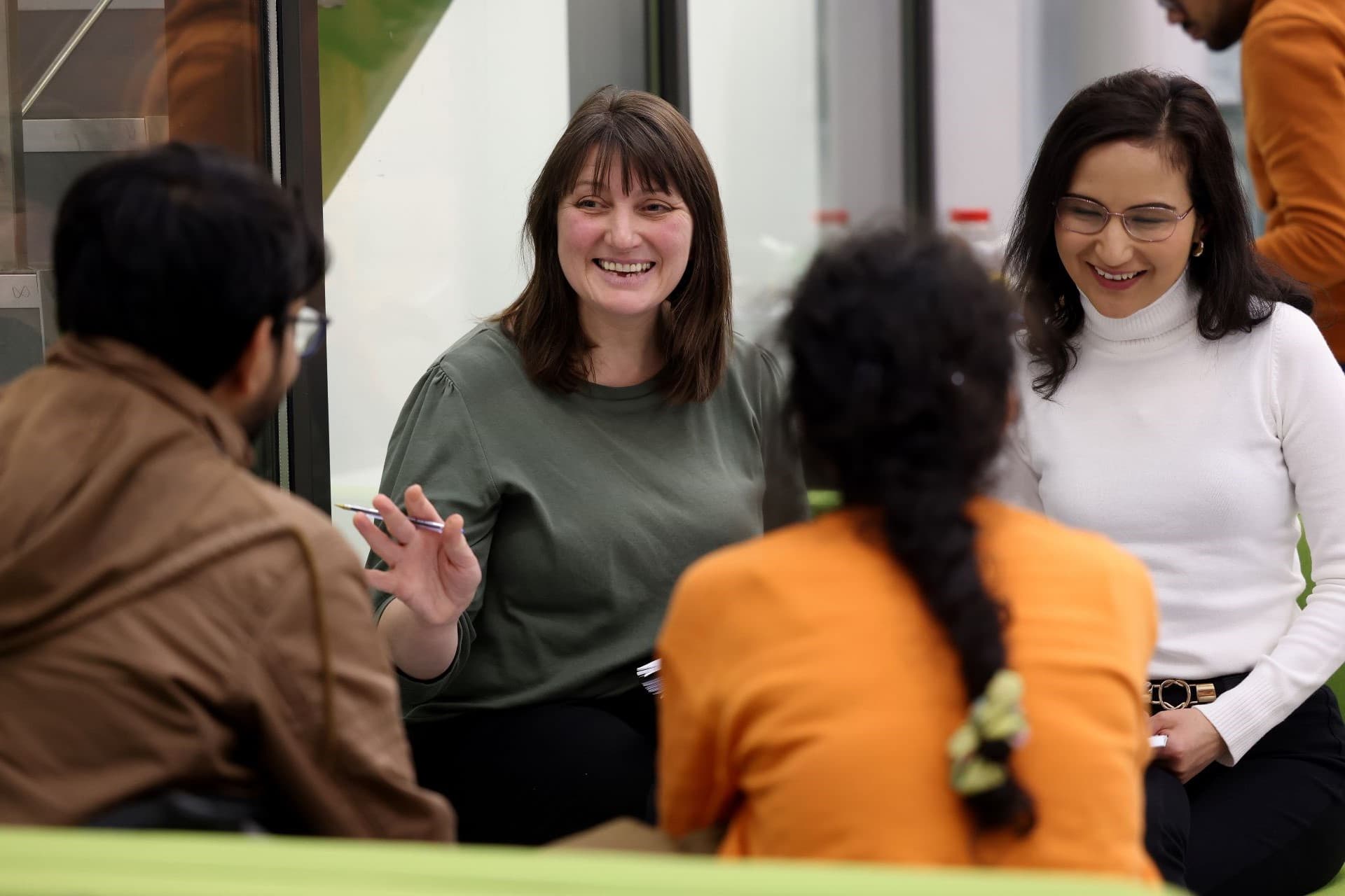 Four members of staff having a conversation. Two people are facing the camera, with the other two people looking the other way.