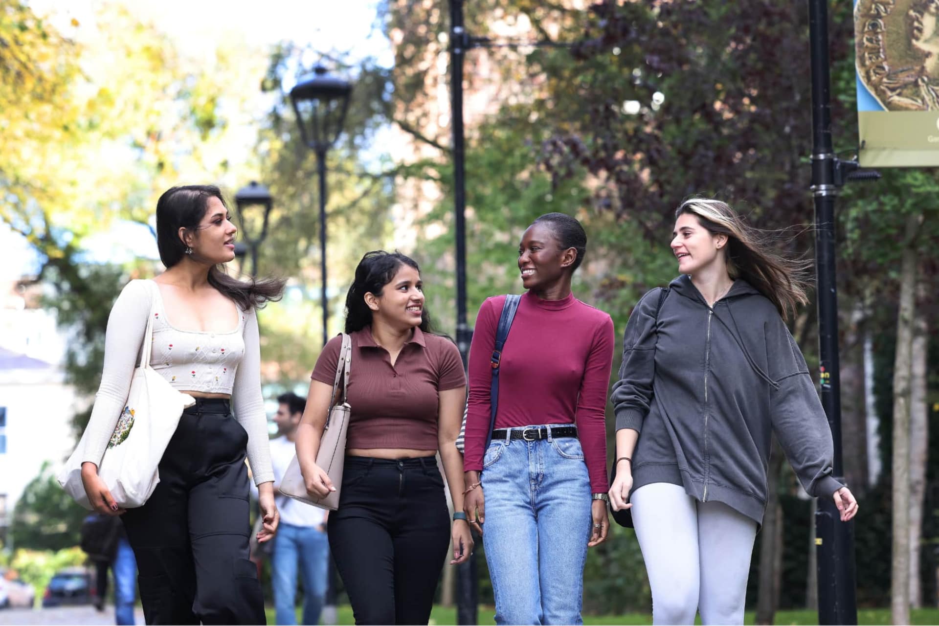 Students walking on campus smiling and talking to each other.