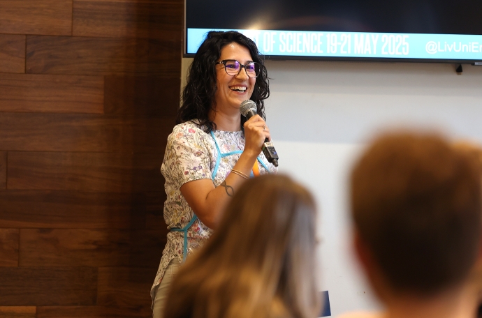 Dr Sibel Cal Kayitmazbatir laughing while holding a microphone