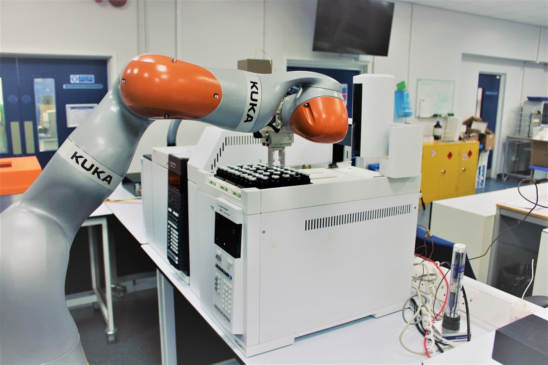 Photograph of a robotic arm piece of equipment inside a laboratory.