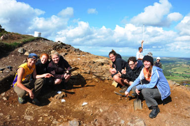 Students at a dig on a hillside