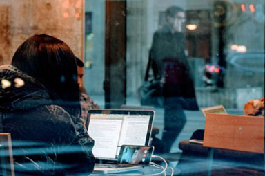 A woman looking at a laptop in a cafe