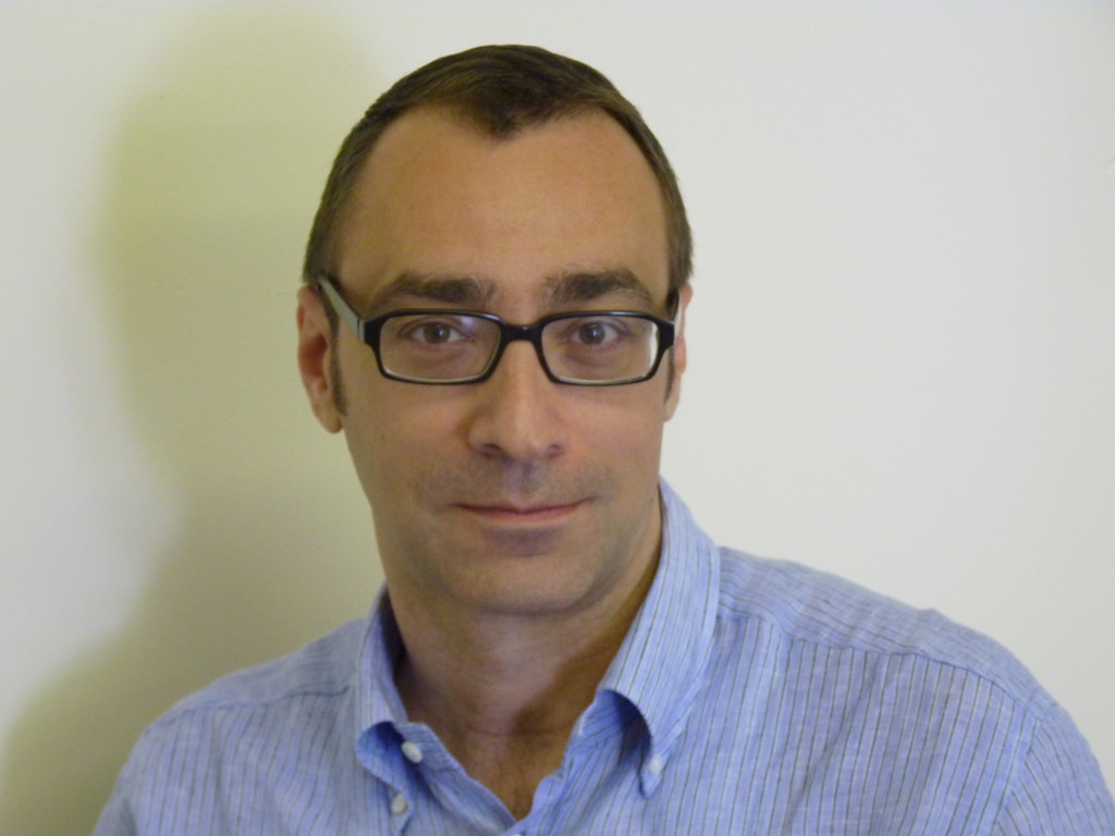 Headshot of male in blue shirt and glasses