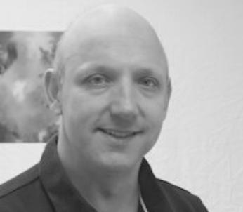 Greyscale image of white male wearing black t-shirt