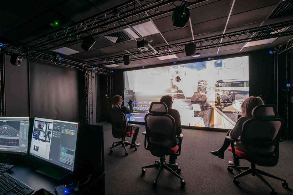 People in chairs watching large screen