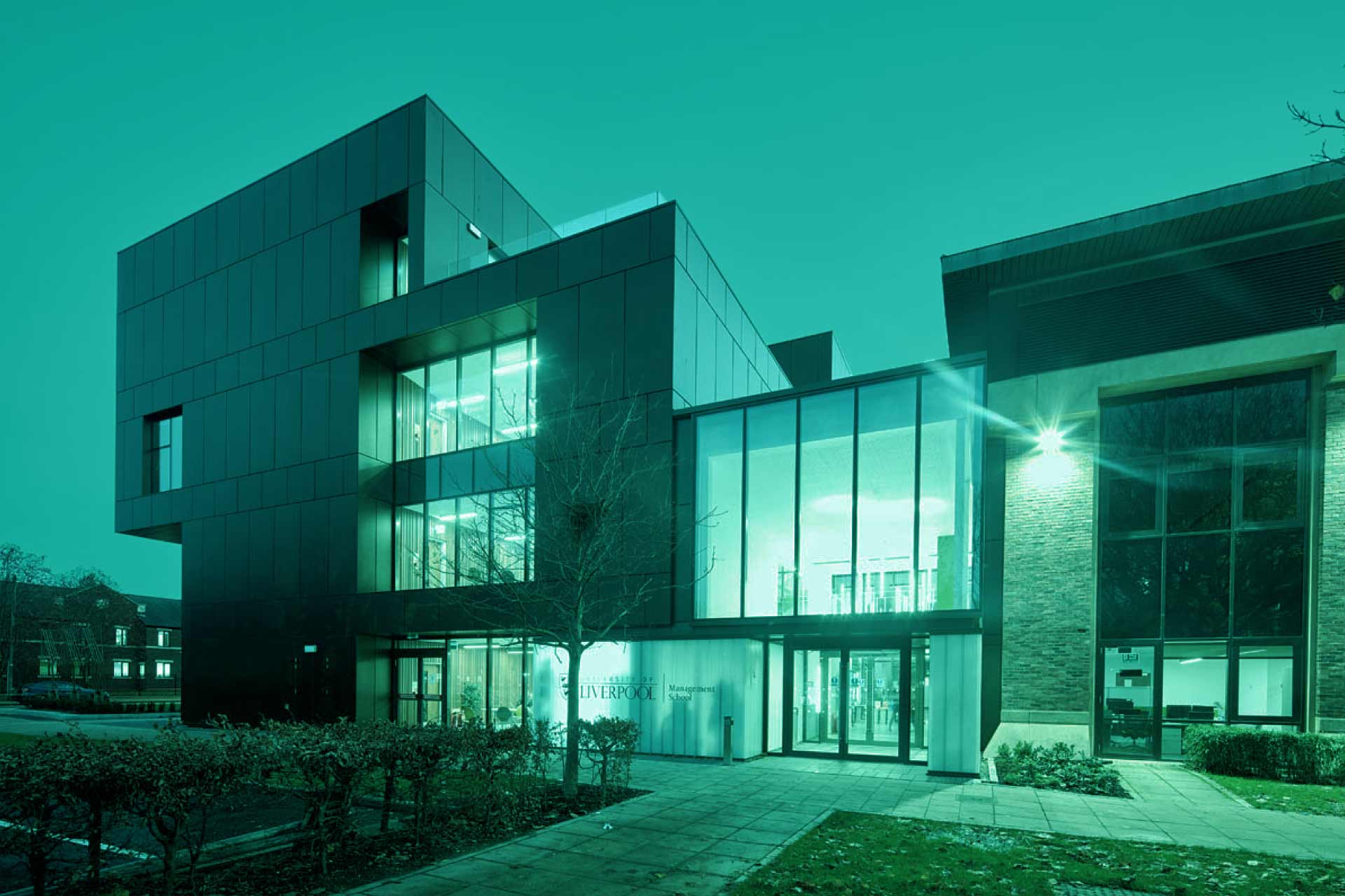 Night image of University of Liverpool Management School tinted in teal