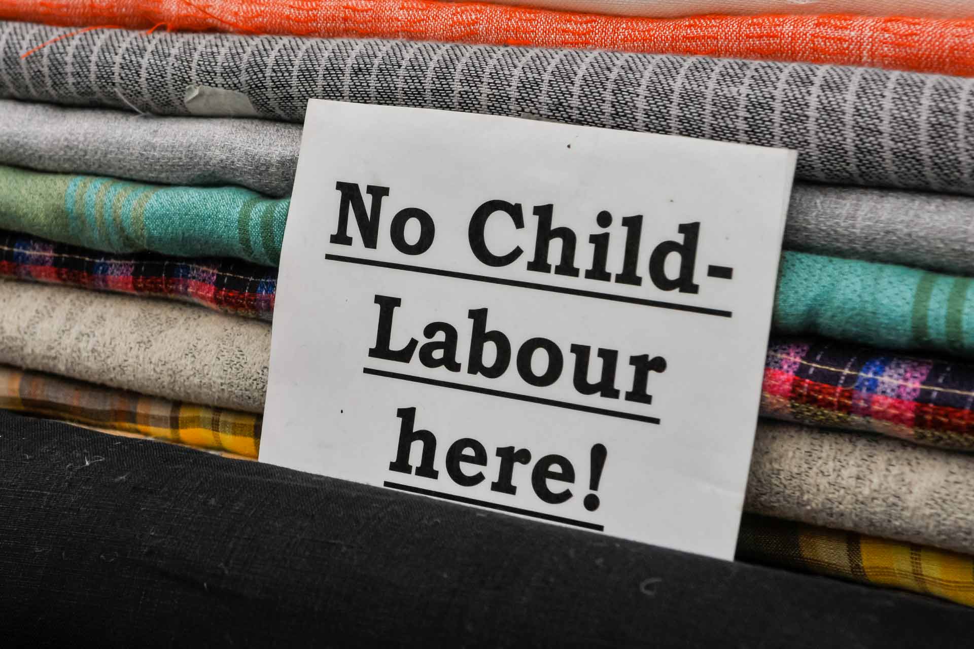 Child labour sign on rack with clothes