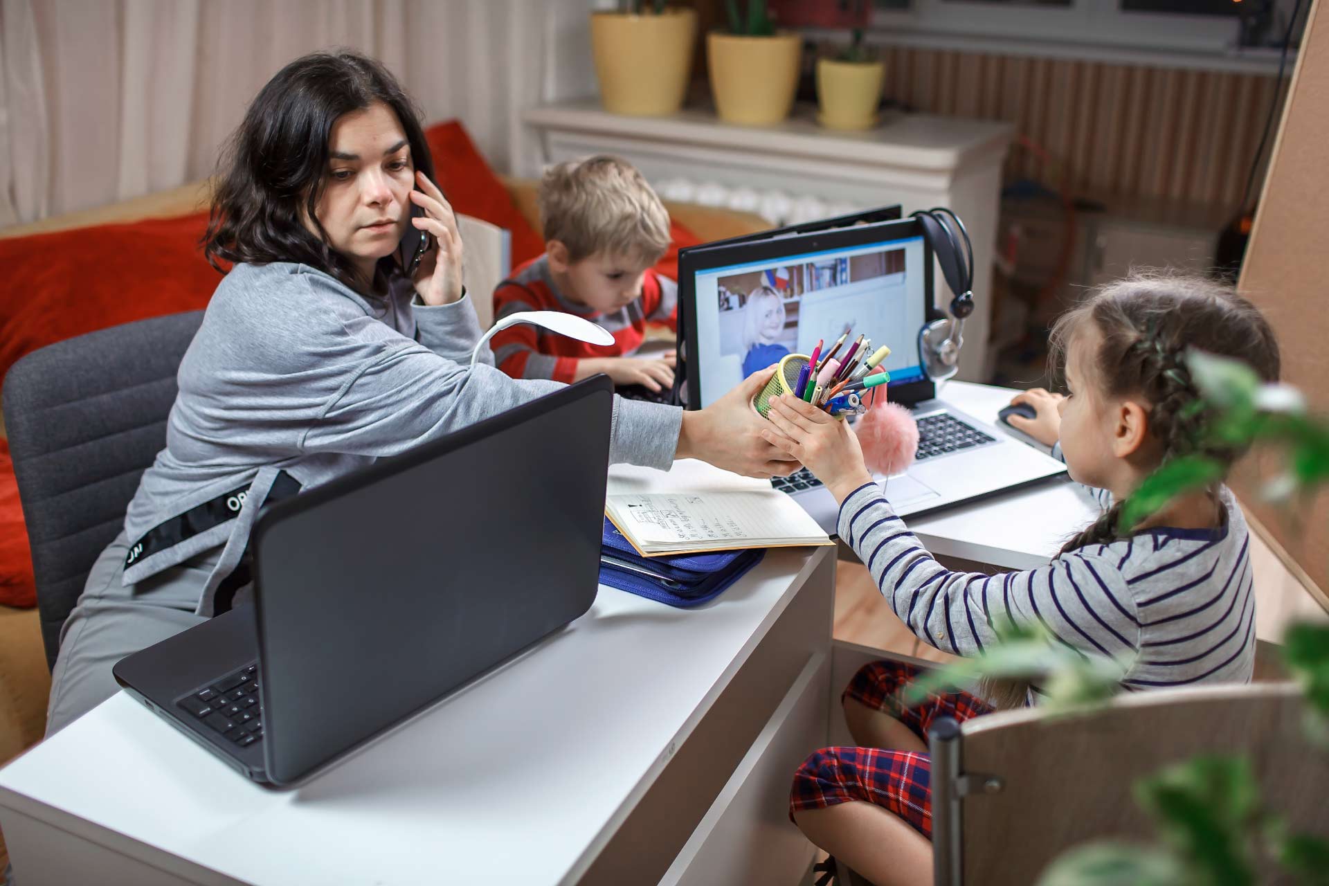 Mother working from home while entertaining her children