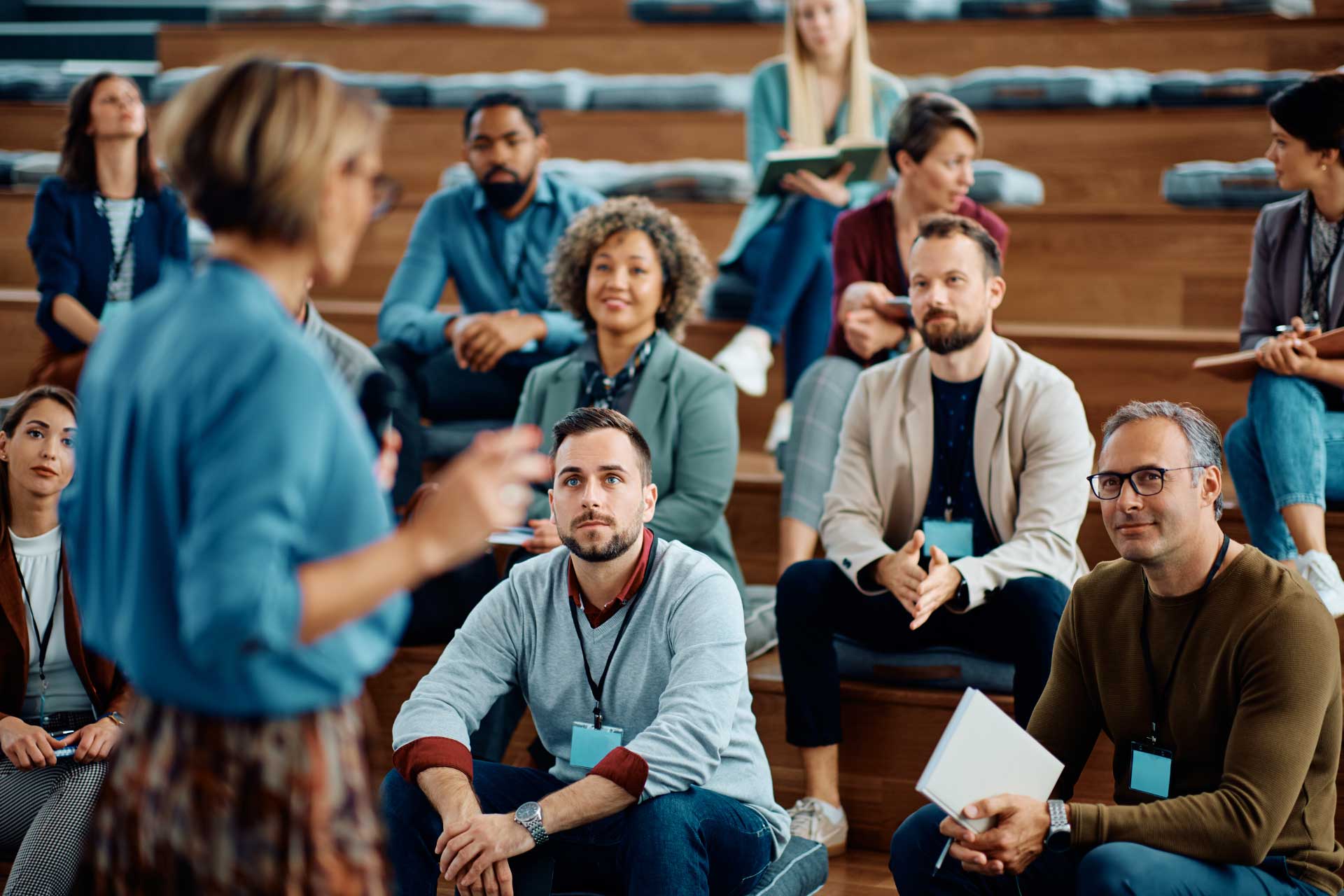Audience listens to female academic during a presentation.