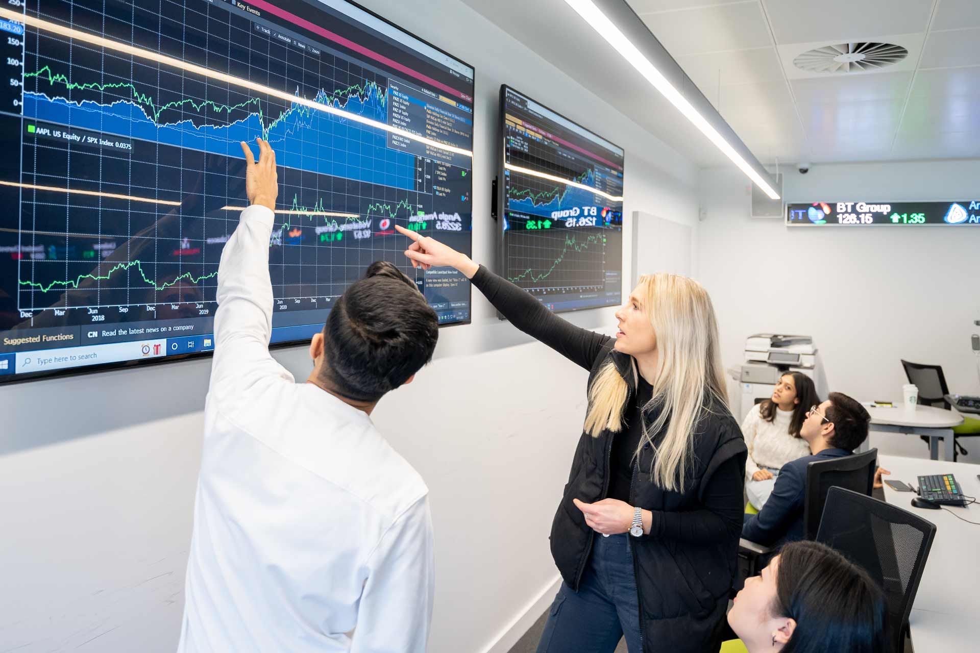 Students analysing on-screen graphics at Bloomberg room