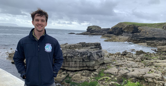 Student doctor Will Jacobs with the coast in the background