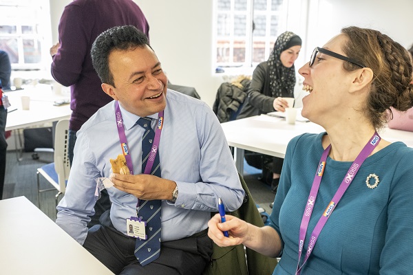 Two colleagues laughing during a workshop