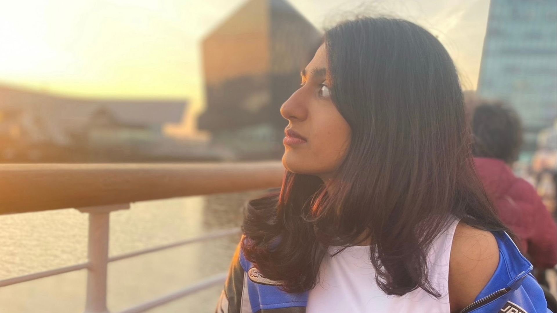 woman looks out onto River Mersey at Albert Dock with modern buildings in the background