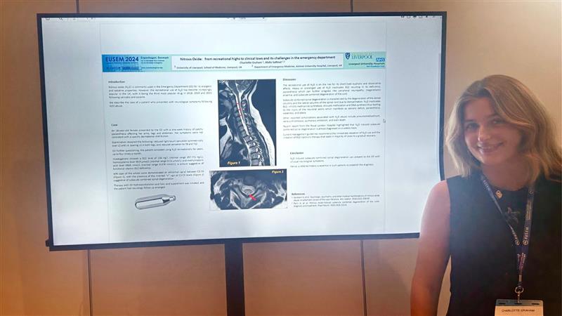 student presents digital poster at conference