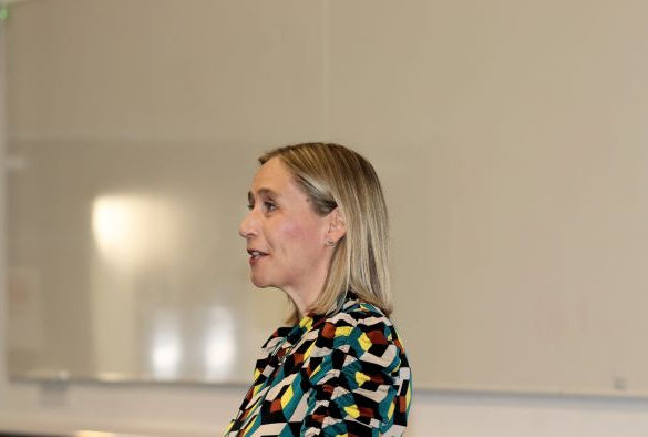 Charlotte Hardman standing in front of a projection screen