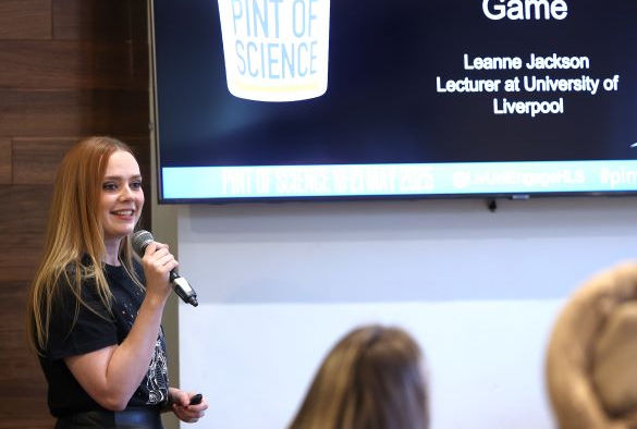 Leanne Jackson holds a microphone in front of a projection screen