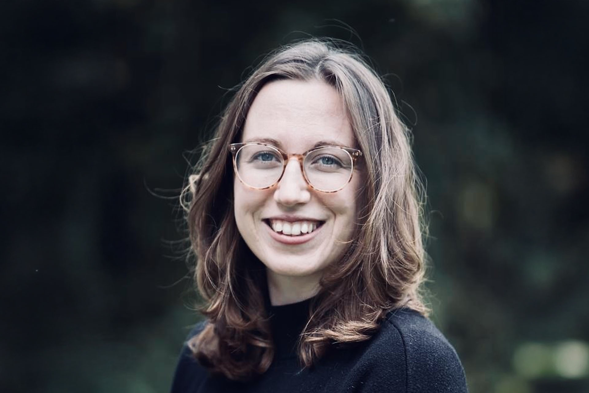 Headshot photo of Dr Nixon smiling against a green background