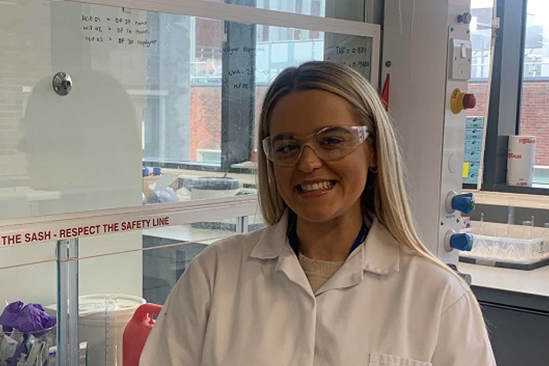 Dr Taylor posing and smiling in a lab