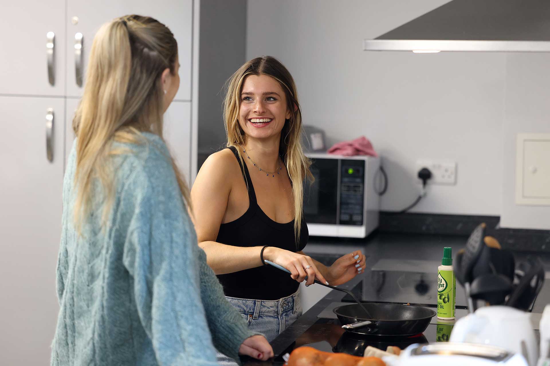 Two students cooking in a kitchen in a hall of residence
