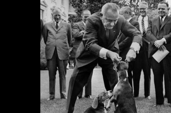President Johnson lifting a dog