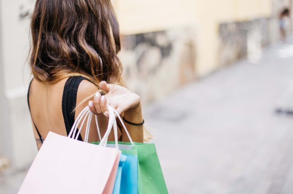 Woman with back to camera carrying shopping bags over her shoulder