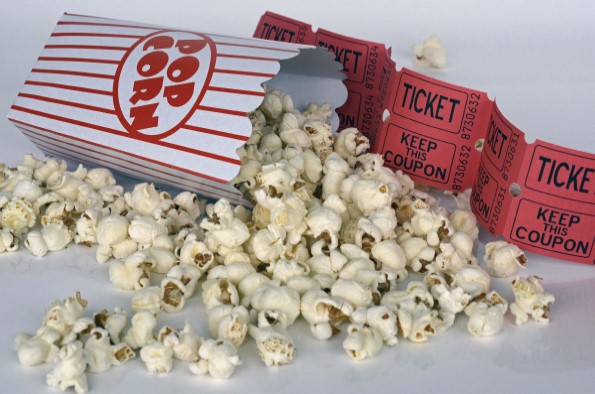 box of spilled popcorn next to a strip of cinema tickets